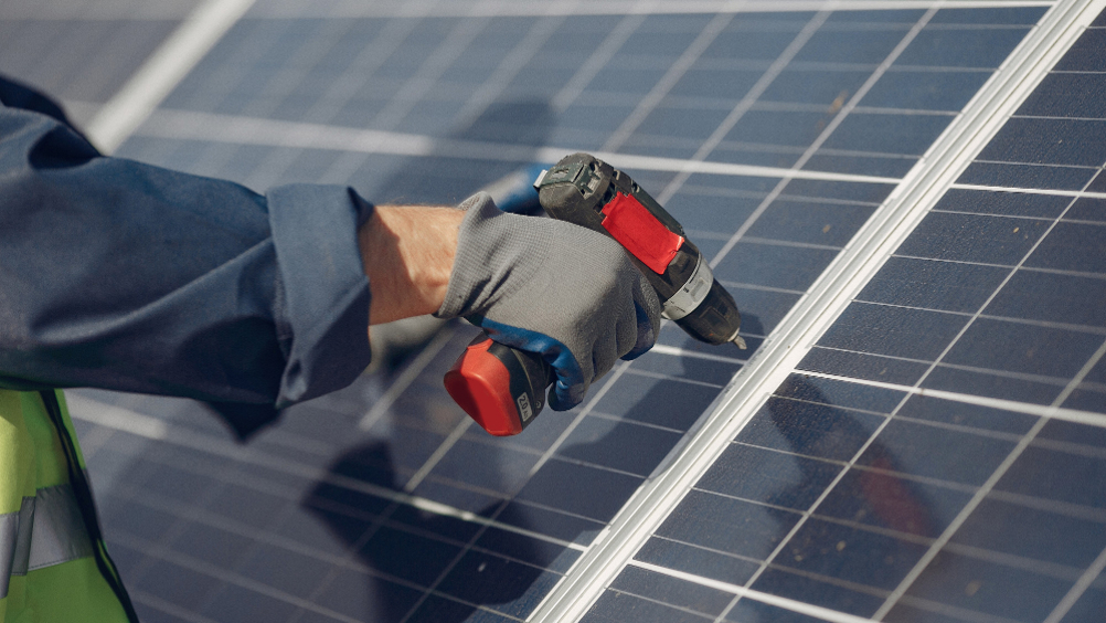 Man with white helmet near a solar panel by Tiger Group 